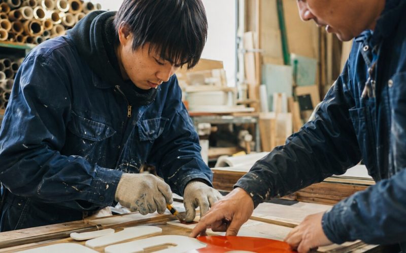 現場で先輩から仕事を学ぶ若手社員の様子